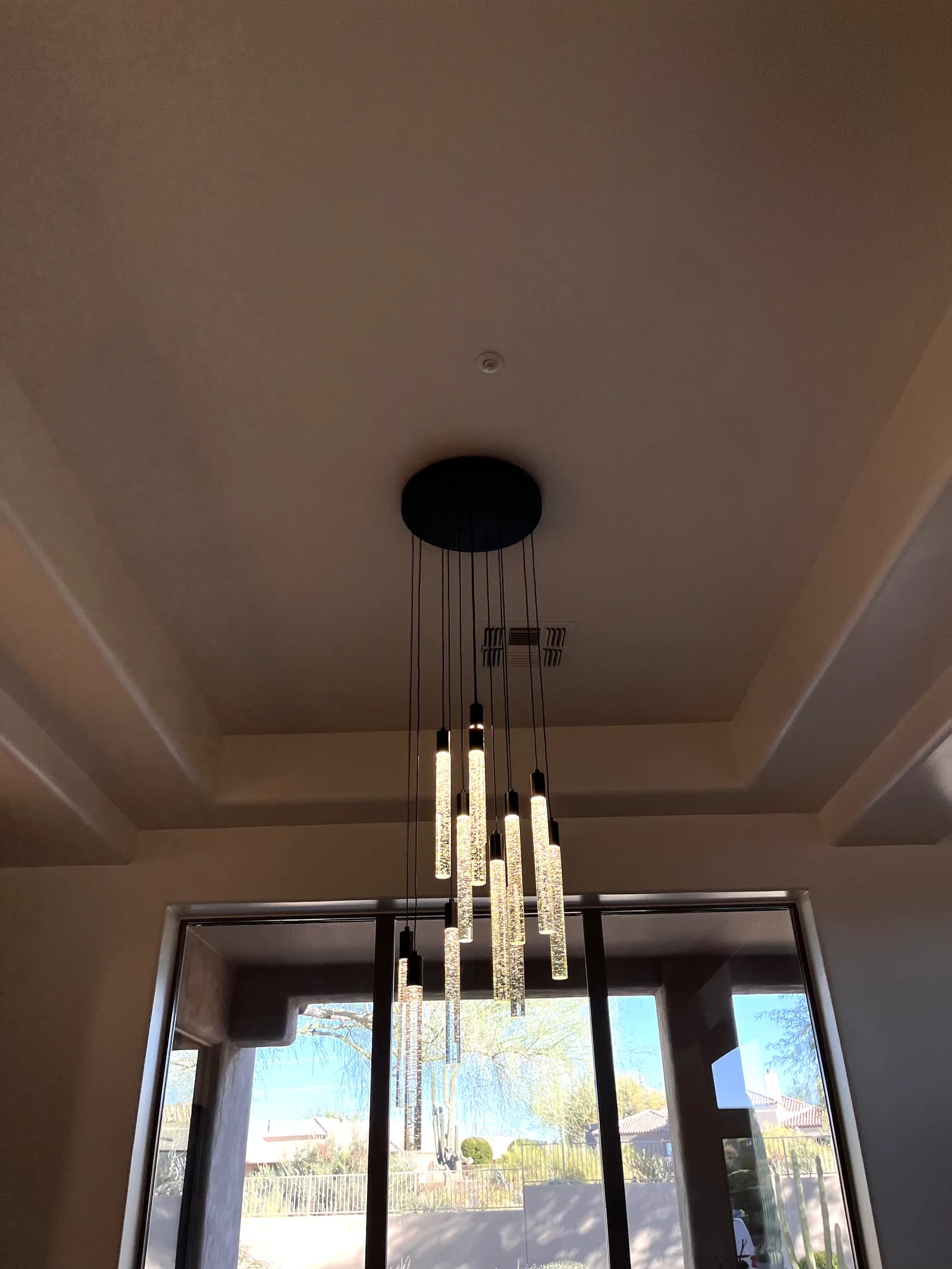 Cluster of seeded-glass pendant lights hanging in front of a large window