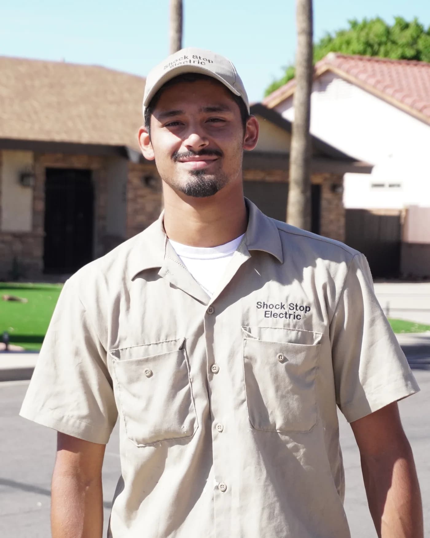 Jason Bottorff, owner of Shock Stop Electric, standing in front of a Phoenix home in his work shirt
